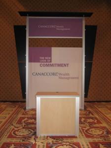 RENTAL Exhibit -- Pavilion with multiple 10&acirc;�� exhibits, arch-shape canopies with black covers, Sintra accent wings, tapered counter workstations, 16&acirc;�� high exhibits, kiosks -- Image 4